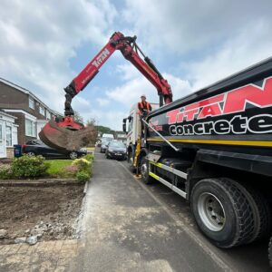 Grab hire truck outside a residential property picking up rubble from front garden.