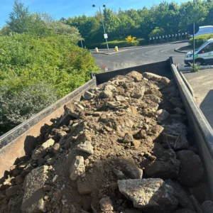 Garden waste rubble in grab hire truck.
