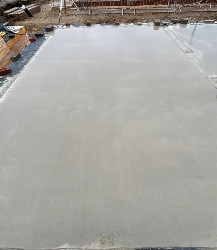 A levelled area of freshly poured concrete in the foreground.